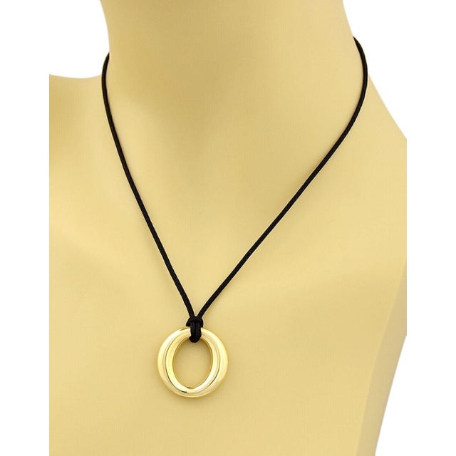 The Tiffany & Co. Peretti Sevillana 18k Yellow Gold & Black Cord Pendant Necklace is a luxurious and elegant piece of...