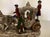A charming group of polychrome porcelain figures depicts a horse-drawn carriage and four figures beares the maker's mark...
