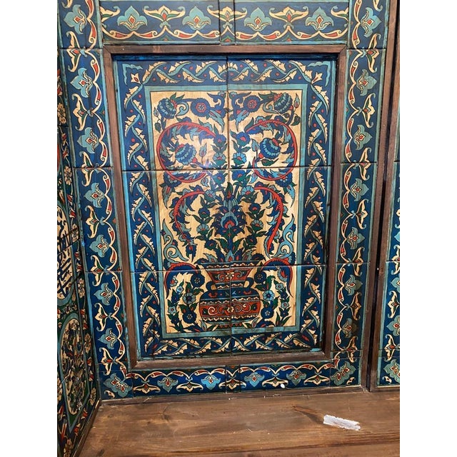 A monumental pair of Maghrebi zouaq-painted wooden doors, the panels worked with Arabic calligraphic cartouches, roundels...