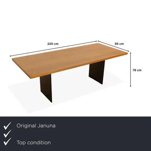 The Janua table features a rectangular wooden tabletop and stands on black legs. Its modern, timeless design distinguishes...