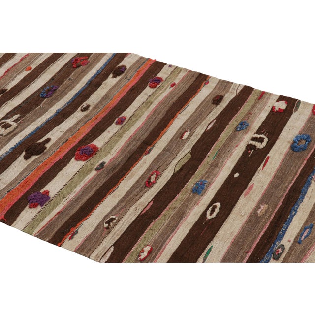 Handwoven in wool and originating from Morocco circa 1950-1960, this 4x7 vintage Moroccan Kilim and runner rug is a...
