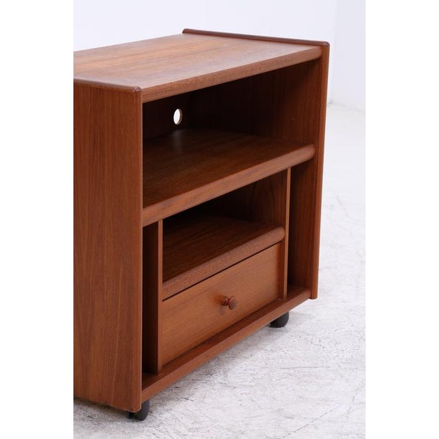 Vintage teak record player cabinet with clean lines and smooth-rolling casters. The combination of open storage and a...