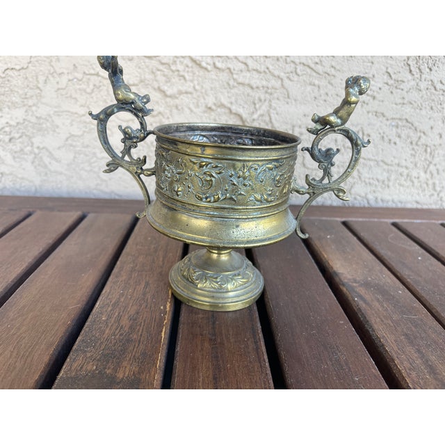 A beautifully crafted piece with intricate Italian design, featuring cherubs on the handles. This Baroque-style urnr adds...