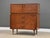 A mid century modern walnut tall dovetail drawer dresser with two doors and rosewood drawer pulls made by Kroehler...
