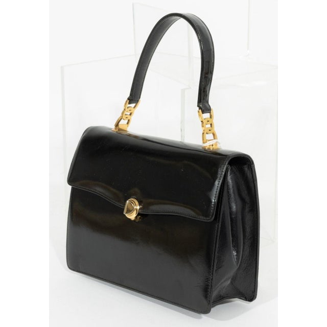 Gucci Black Patent Leather Handbag, with top handle, gold-tone metal hardware, single interior zipper pocket and two slip...