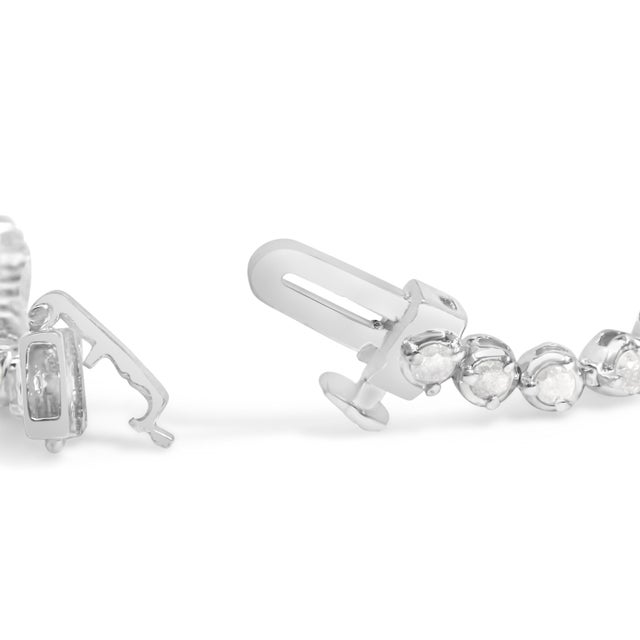 Envelop your wrist in the sheer elegance of this sterling silver tennis bracelet, where simplicity meets sophistication in...