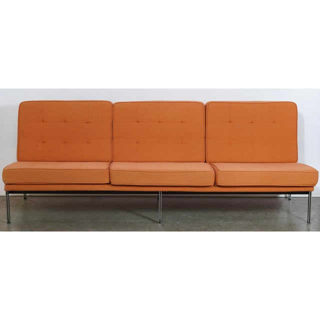 Florence Knoll's parallel bar sofa, model 53, places an armless angled seat upon a squared-off steel frame with a brushed...