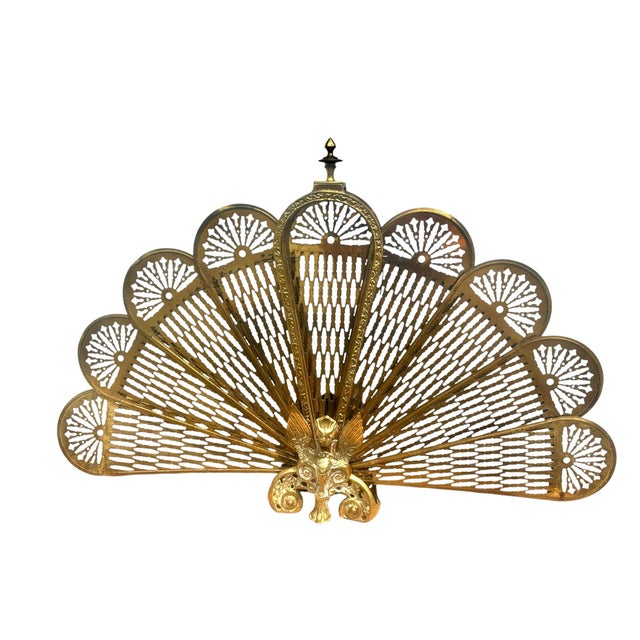 Vintage brass plated folding screen for the fireplace. Peacock style fan that opens up. You can use it decoratively as...