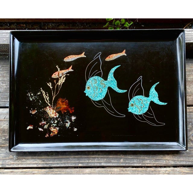 A striking vintage Couroc of Monterey serving tray featuring two whimsical turquoise angel fish swimming across a dramatic...