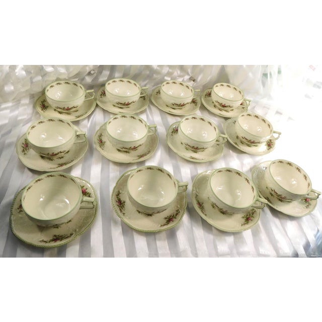 This is a lot of Twelve Rosenthal Sansscouci Rose Ivory Flat teacup and saucer sets with green trim. They are ivory color...