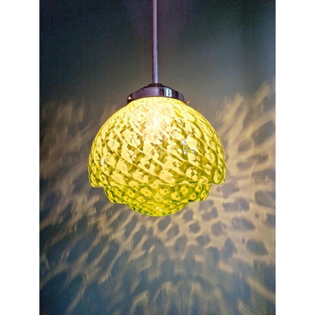 Large pendant light in green and white speckled glass with a chrome-plated metal frame. This pendant light is in the Art...