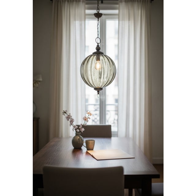 This elegant 1960s pendant light features a hand-blown Murano glass globe in a warm bronze tone, paired with finely...