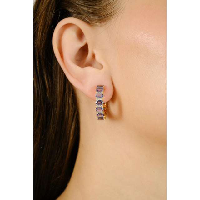 These hoop earrings feature 6.61 carats of octagon-cut tanzanite's accented with 0.39 carats round brilliant-cut diamonds...