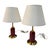 Elegant pair of vintage table lamps featuring deep red cylindrical bases with polished brass accents and wide cream linen...