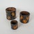 A rare and character-rich set of three antique Nepalese grain measures, dating to circa 1900, presented as a graduated...