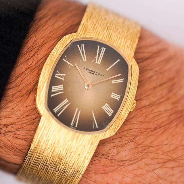 Audemars Piguet ellipse watch featuring slim 28mm cushion case in 18K yellow gold with champagne gradient dial and Roman...