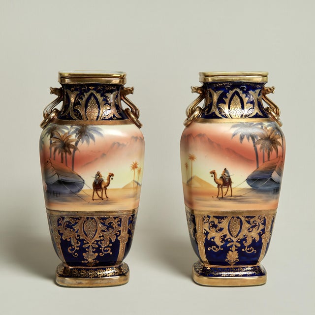 A rare true mirror pair of orientalist porcelain vases decorated in cobalt and gold featuring hand painted nomadic desert...