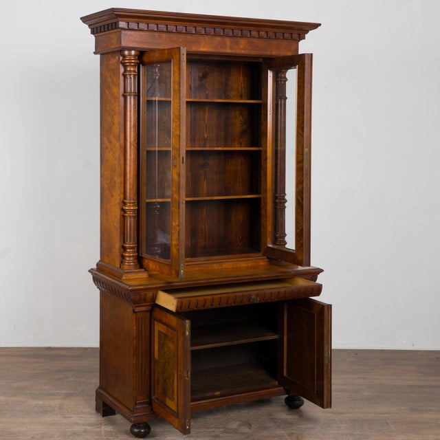 20th century Danish bookcase crafted in walnut. The upper cabinet features glass panes allowing display of books or any...
