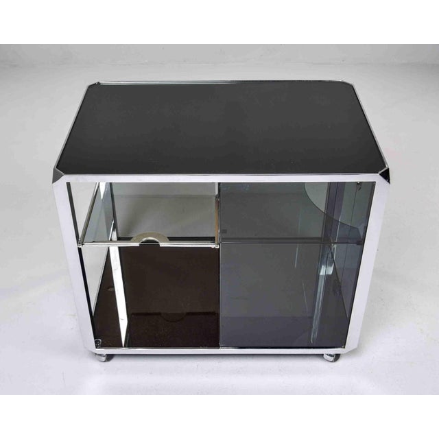 This Italian rolling bar cart by Willy Rizzo for Mario Sabot dates from the 1970s and is constructed of smoked grey glass...