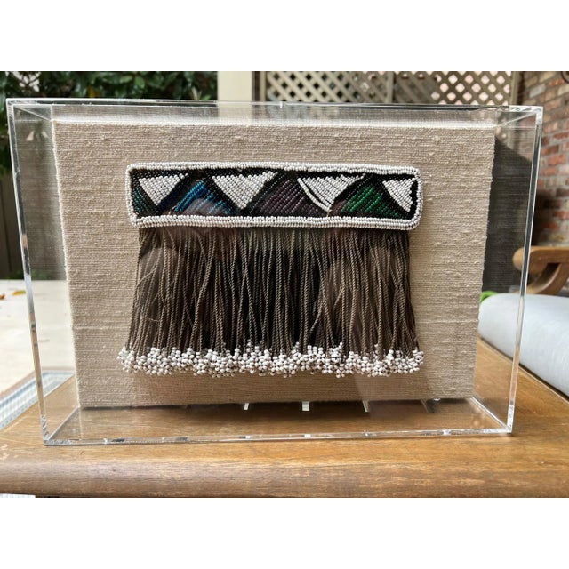Girls apron (Lighabi) made of glass beads and hide. Worn by small children, girls. Displayed in an acrylic shadowbox. The...