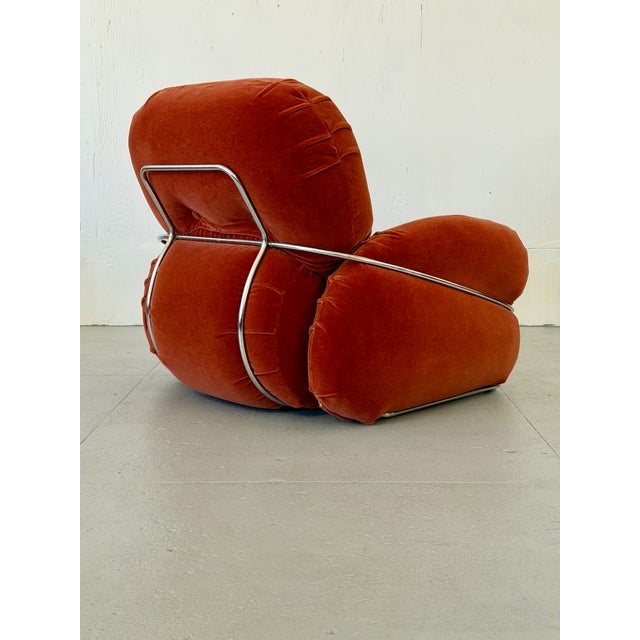 Instantly recognizable by its sculptural chrome frame, this 'Okay' series armchair wraps you in plush rose-toned mohair...