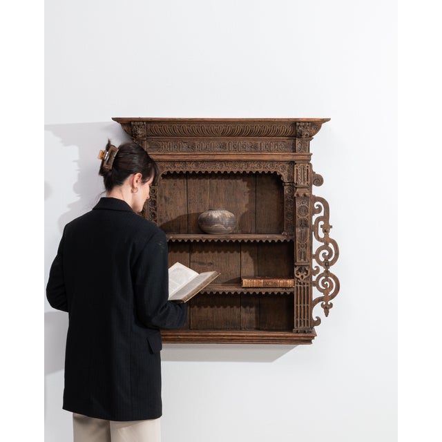 This 19th century Renaissance bookcase from Belgium is finished in brown, worked in wood. Its carved detailing gives the...