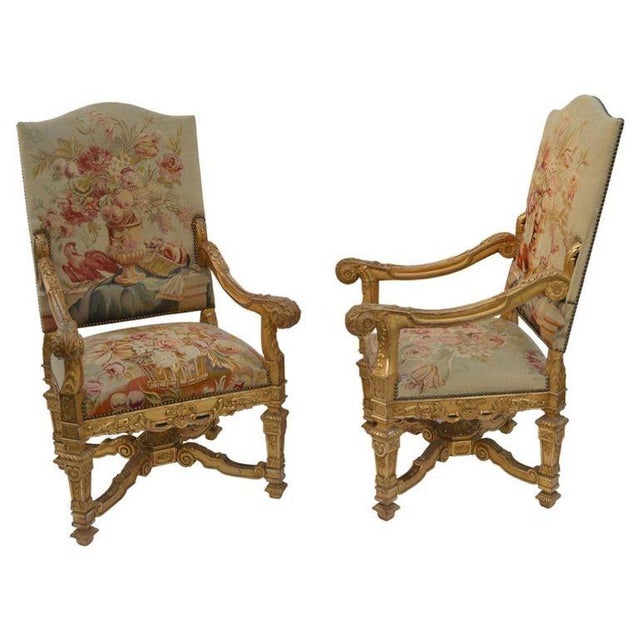 A magnificent pair of late 19th-century French Neoclassical armchairs, expertly hand-carved from walnut and water-gilded...