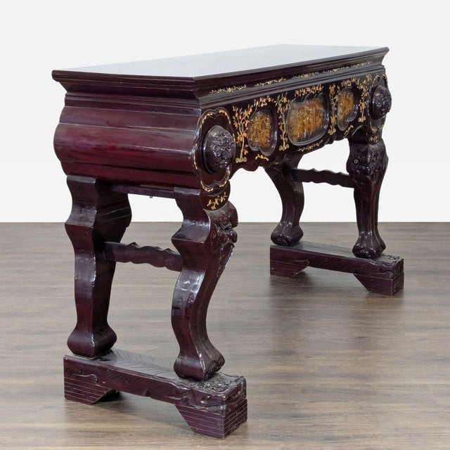 Carved table with stylized deity base, 2 drawers, carved panels with figures, animals, and floral designs, and mother of...