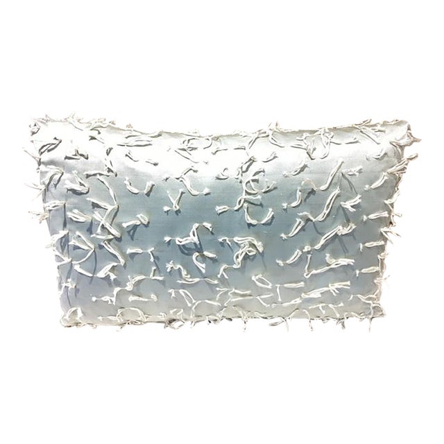 Rectangular pillow made from a silky, satin like fabric in a soft cream tone. The surface has a subtle sheen that catches...