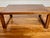 An antique Chinese low table exuding Ming Dynasty simplicity with a natural wood grain finish and simple rectilinear legs...