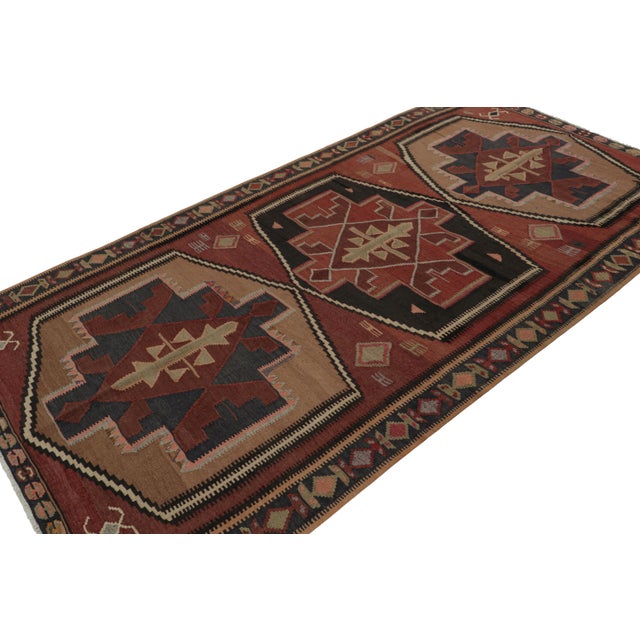 Handwoven in wool, circa 1950-1960, this 5x9 vintage tribal Afghan kilim rug features large-scale medallions with...
