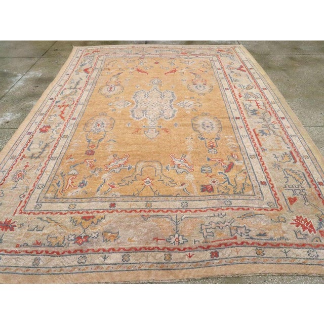 An antique Turkish Oushak room size carpet handmade during the Early 20th century. Measures: 8' 5" x 11' 7"