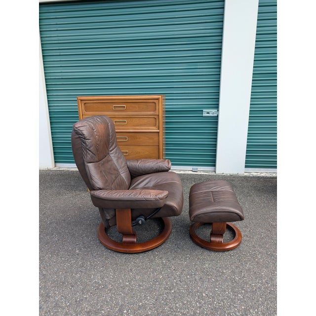 Super comfortable, Norwegian made vintage MCM style Ekornes Stressless recliner and ottoman pair. Thick dark brown...