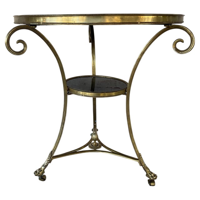 Neoclassical Brass and Black Stone Gueridon Side Table, designed in the French Louis XVI Neoclassical manner. It features...