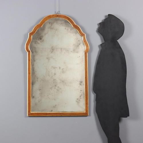 Walnut mirror with curved frame at the top, gilded carvings, mercury mirror. Italy, 19th century. This piece is attributed...