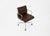 Brown leather armchair with an aluminum base and wheels. The chair swivels. Stamped Herman Miller. Wear consistent with...