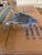 This is a sleek, blue-tinted art glass sculpture shaped like a jumping dolphin. It is crafted with a transparent finish...