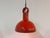 Large dining table lamp made of glossy, lacquered ceramic in a vibrant red. The wide shade provides a pleasant, downward-...