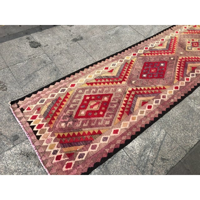 This is a vintage Turkish Anatolian kilim rug from the 1960s. The piece was hand-woven.