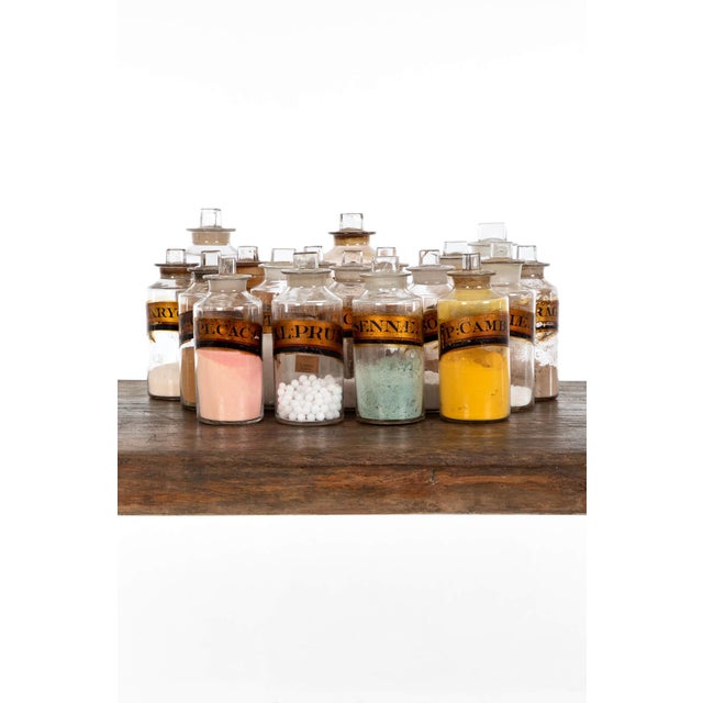 A collection of eighteen georgian apothecary bottles from a british museum with original contents to each. Each bottle...