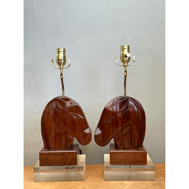 This distinguished pair of vintage carved wood horse head table lamps beautifully combines organic craftsmanship with the...