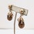 1950s goldtone round domed top with brown moonglow resin drop with curled top "cumquat" clip earrings. Marked "NAPIER" in...