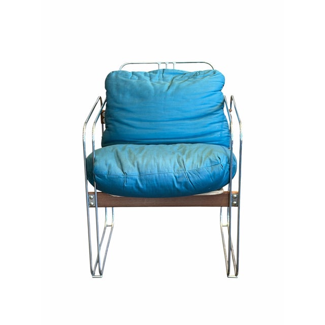 Set of four vintage chrome lounge chairs featuring sleek tubular frames paired with cerulean blue upholstered cushions....