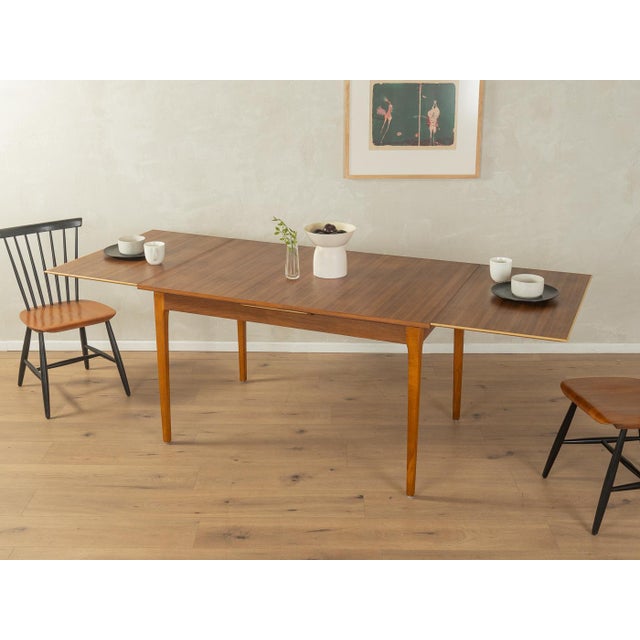 Classic extendable dining table from the 1960s. Solid beech frame and walnut veneer tabletop. Quality features: Excellent...