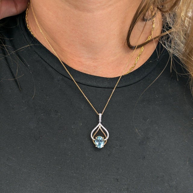 A 2.99-carat aquamarine glows in a soft sky-blue at the centre of this solid two-tone 14K white and rose gold pendant,...