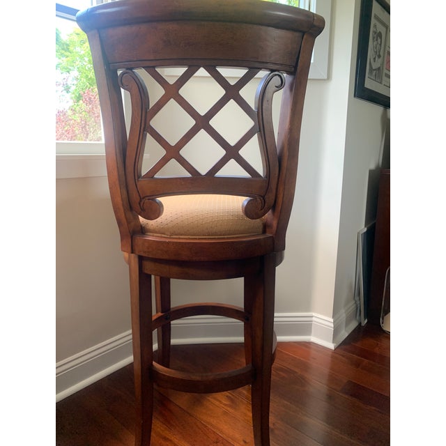 Heavy decorative cherrywood finish bar stools. Swivel seats. Fabric seating with polyurethane foam. Decorative Celtic harp...