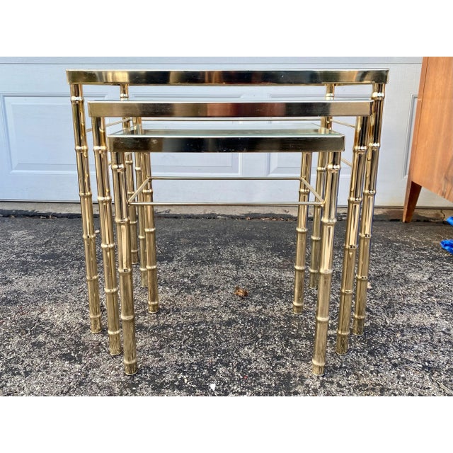 Lovely like-new faux bamboo brass nesting tables. This sturdy set of three brass-toned chinoiserie nesting tables have...