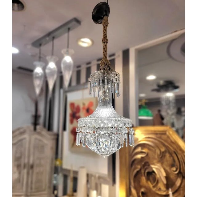 Italian chandelier in faceted and cut crystal. The body is made entirely of glass with a cable hidden by a braided cord in...