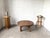 A round, Brutalist coffee table from the 1950s, crafted from solid pine, in a modernist aesthetic. This unique piece is...