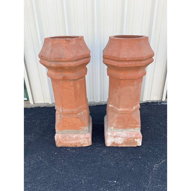 A beautiful pair of antique terracotta chimney pots. These unglazed chimney pots hail from the early part of the 20th...